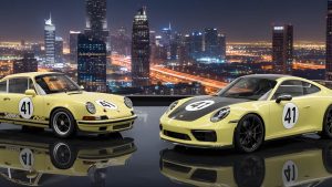 A vintage and a modern yellow Porsche, both featuring the racing number 41 and black decals, are parked in a rustic industrial garage